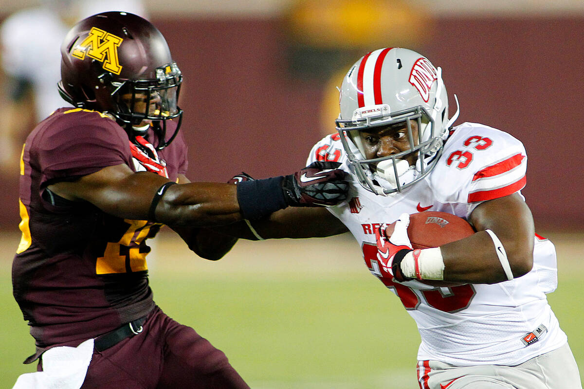 UNLV running back Shaquille Murray-Lawrence (33) runs past Minnesota defensive back Marcus Jone ...