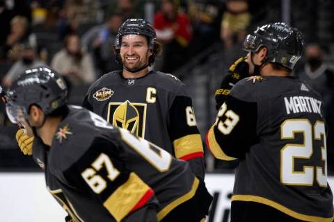 Golden Knights right wing Mark Stone (61) smiles in between the action next to left wing Max Pa ...
