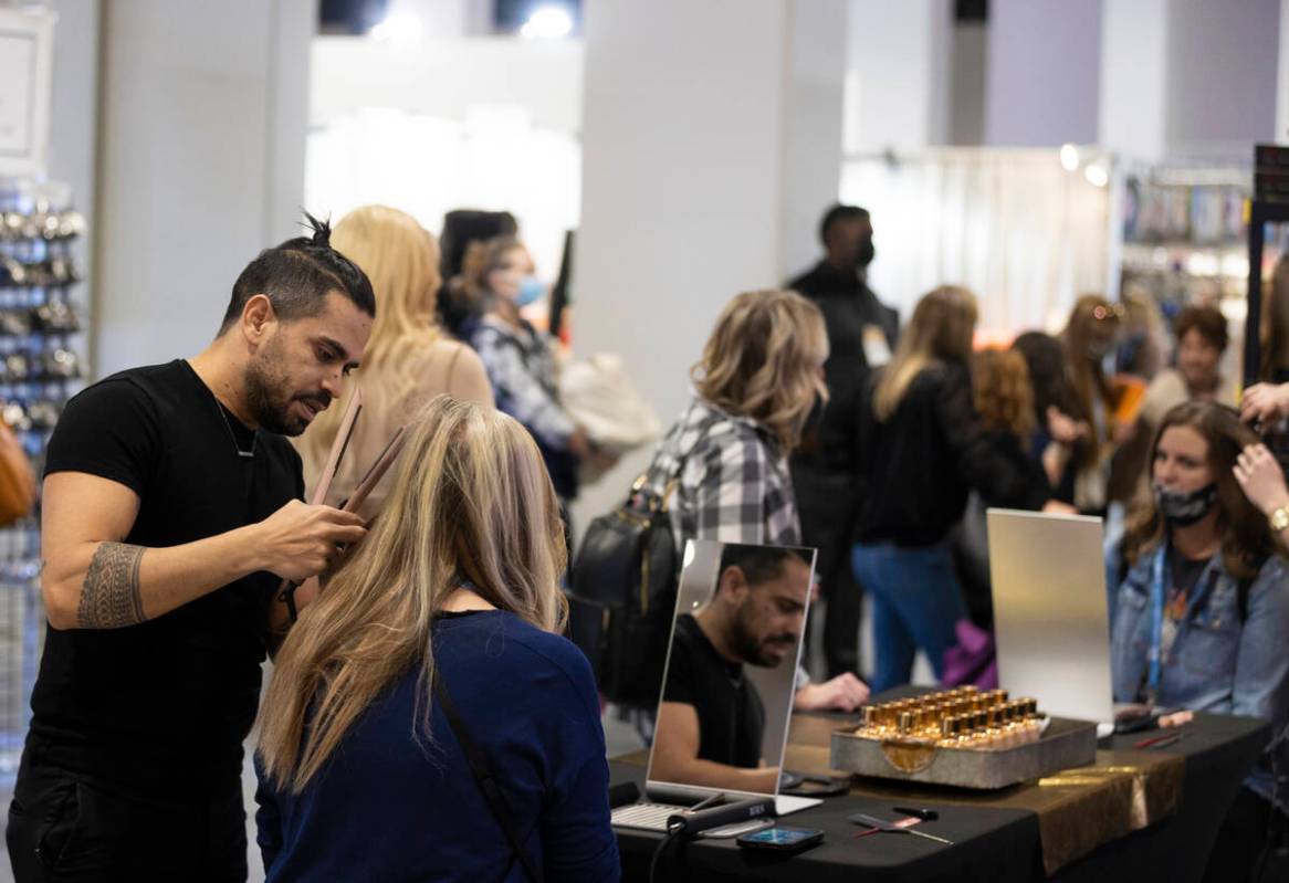 Hair stylist Adam Lewis, left, works with a client during the Las Vegas Market at World Market ...