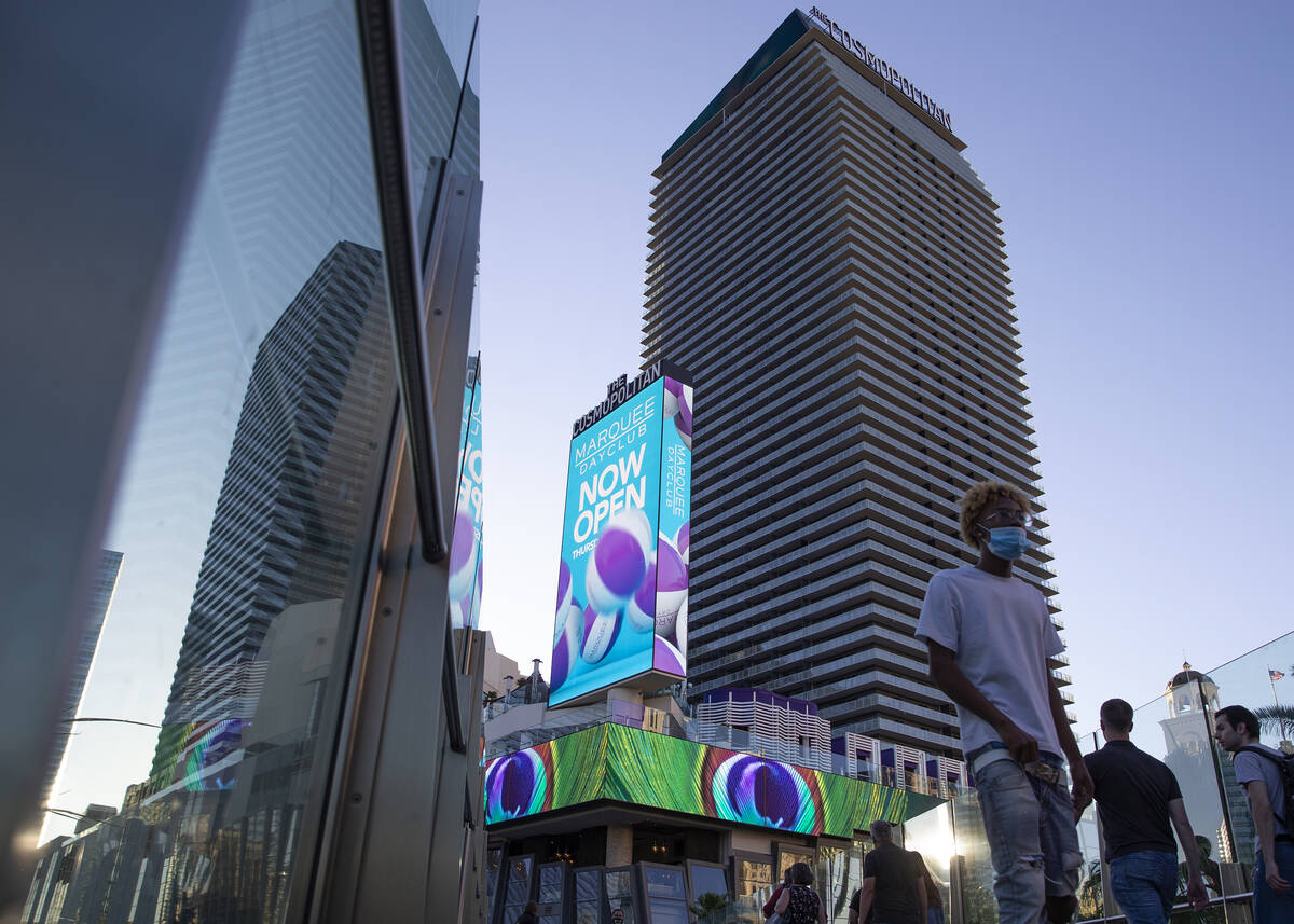 Visitors to the Las Vegas Strip cross a pedestrian bridge outside Cosmopolitan of Las Vegas on ...