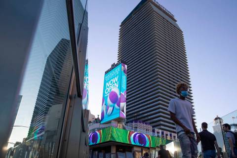 Visitors to the Las Vegas Strip cross a pedestrian bridge outside Cosmopolitan of Las Vegas on ...