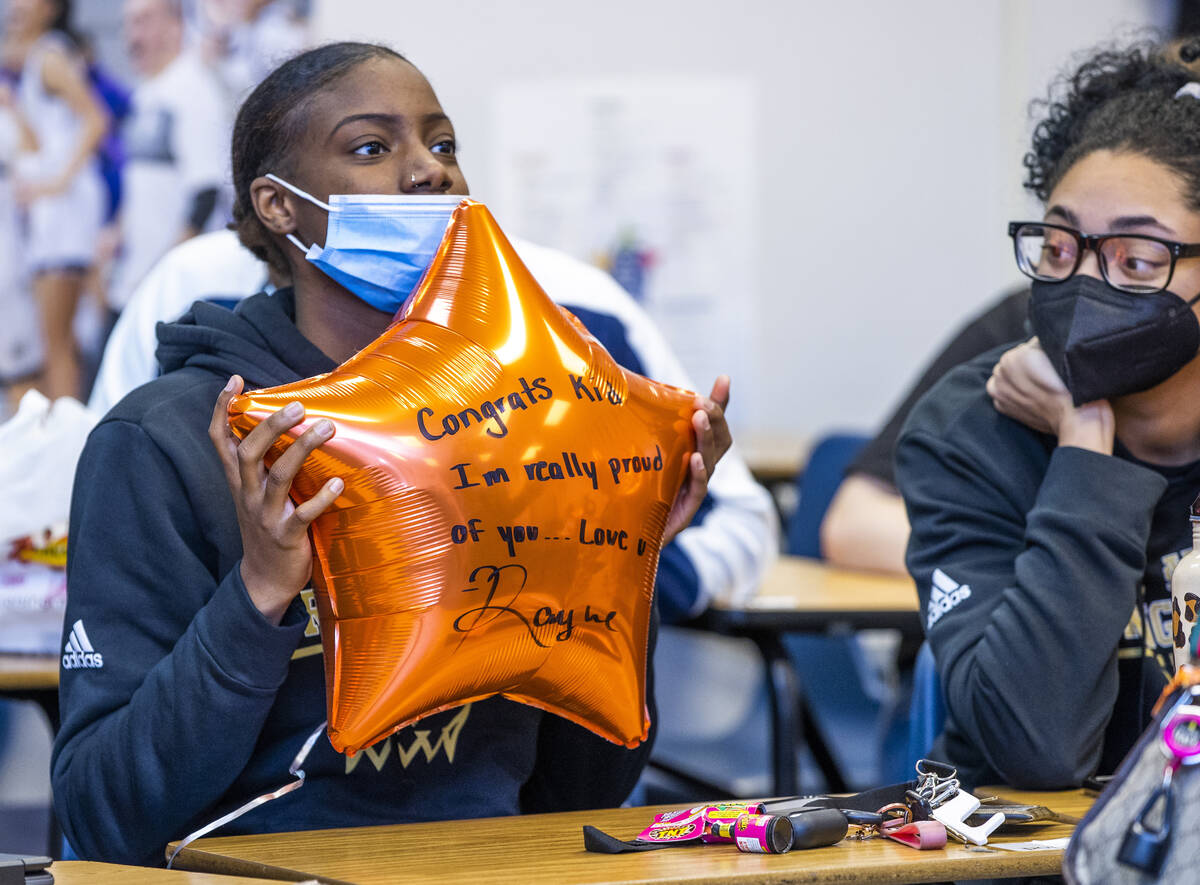 A teammate shows off her best wishes to Spring Valley High School basketball guard Aaliyah Gayl ...