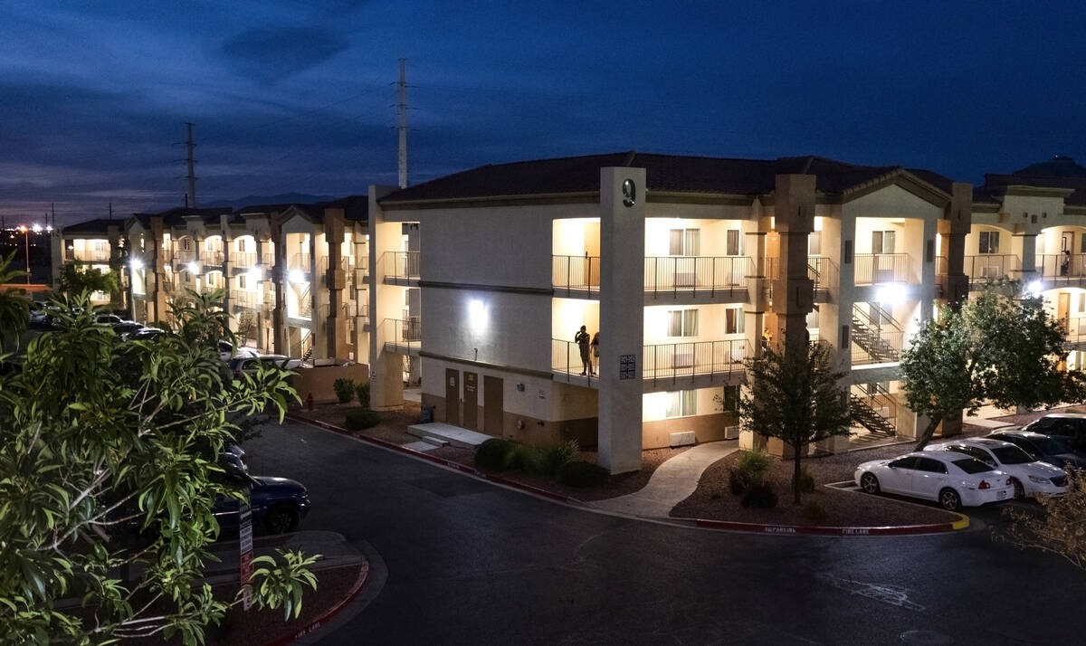 Residents hang out on the balcony of one of many buildings at the Siena Suites extended-stay mo ...