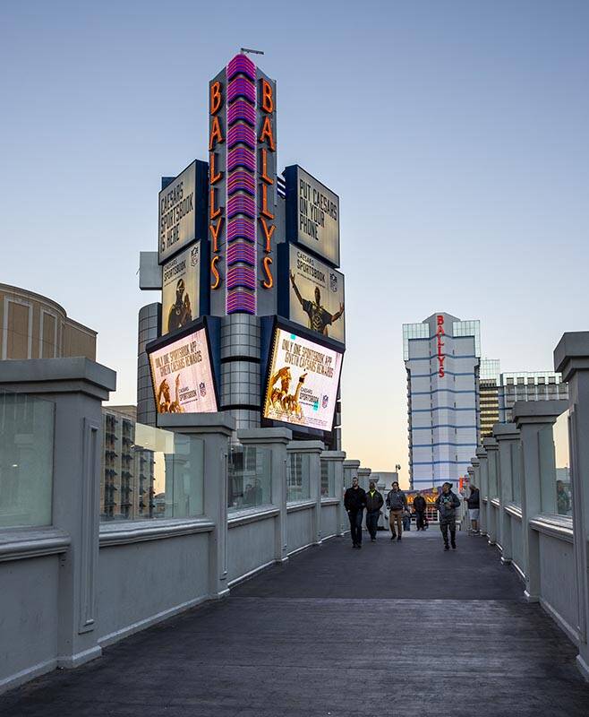 People walk along a pedestrian bridge in front of the exterior of Bally’s Las Vegas whic ...