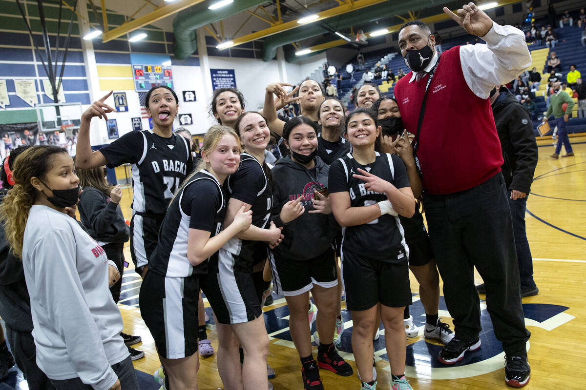 The Desert Oasis girls high school basketball team celebrates with a photo after winning a game ...
