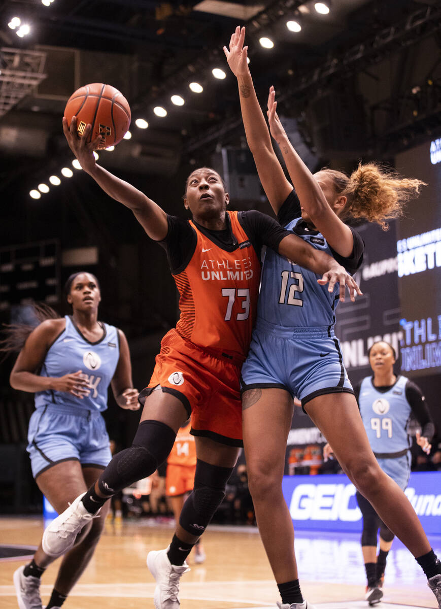 Team Russell’s Danielle McCray (73) slices to the rim past Team Sims’ Kiki Harrig ...