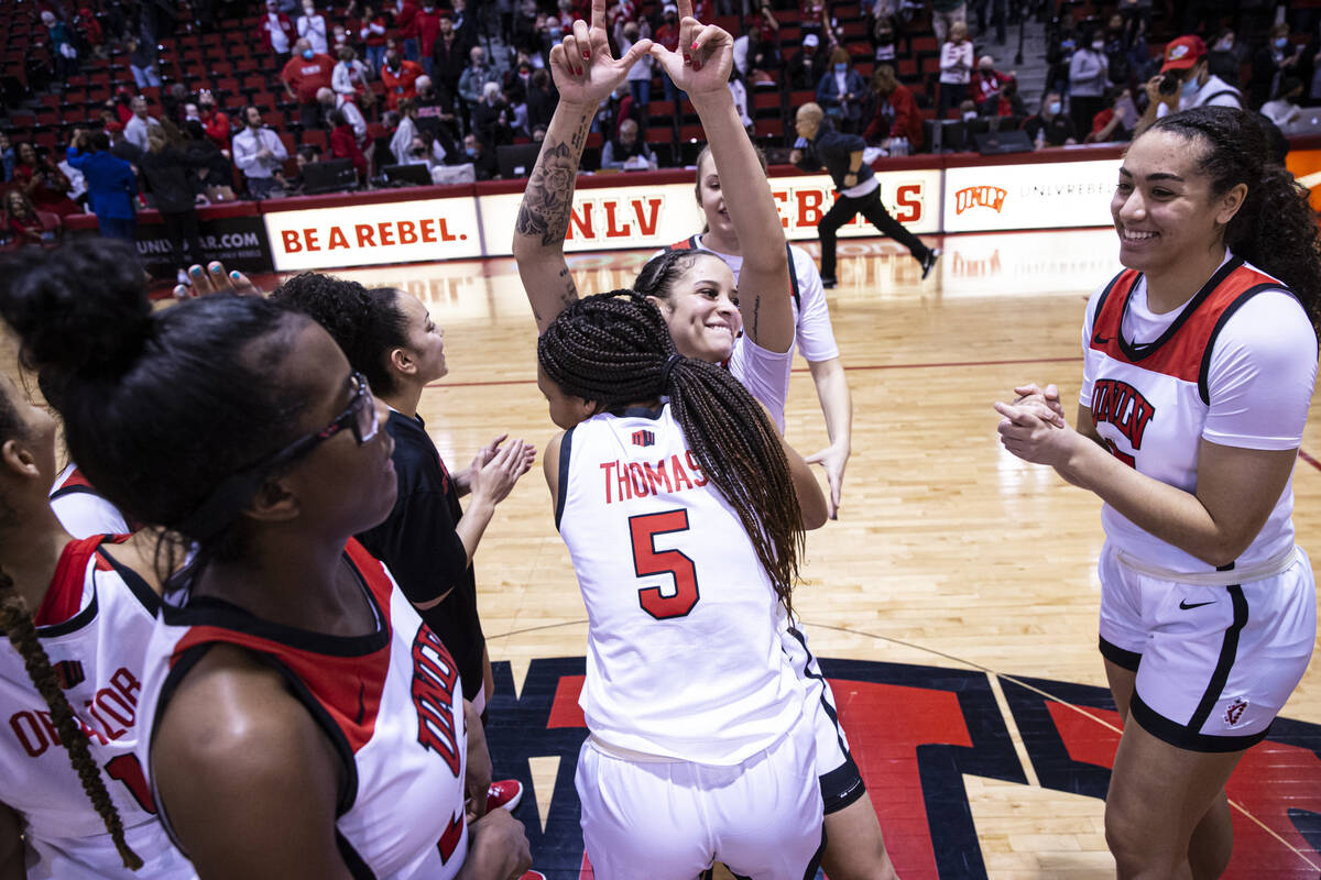 UNLV Lady Rebels guard Essence Booker, center, celebrates after reaching 1,000 career points an ...