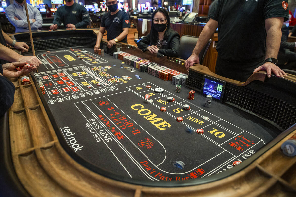 A guest tosses the dice during a game of Craps at Red Rock Casino on Tuesday, Dec. 26, 2021, in ...