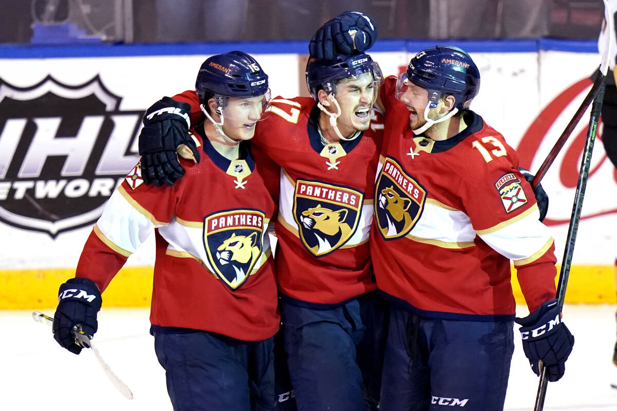 Florida Panthers left wing Mason Marchment, center, celebrates with center Anton Lundell, left, ...
