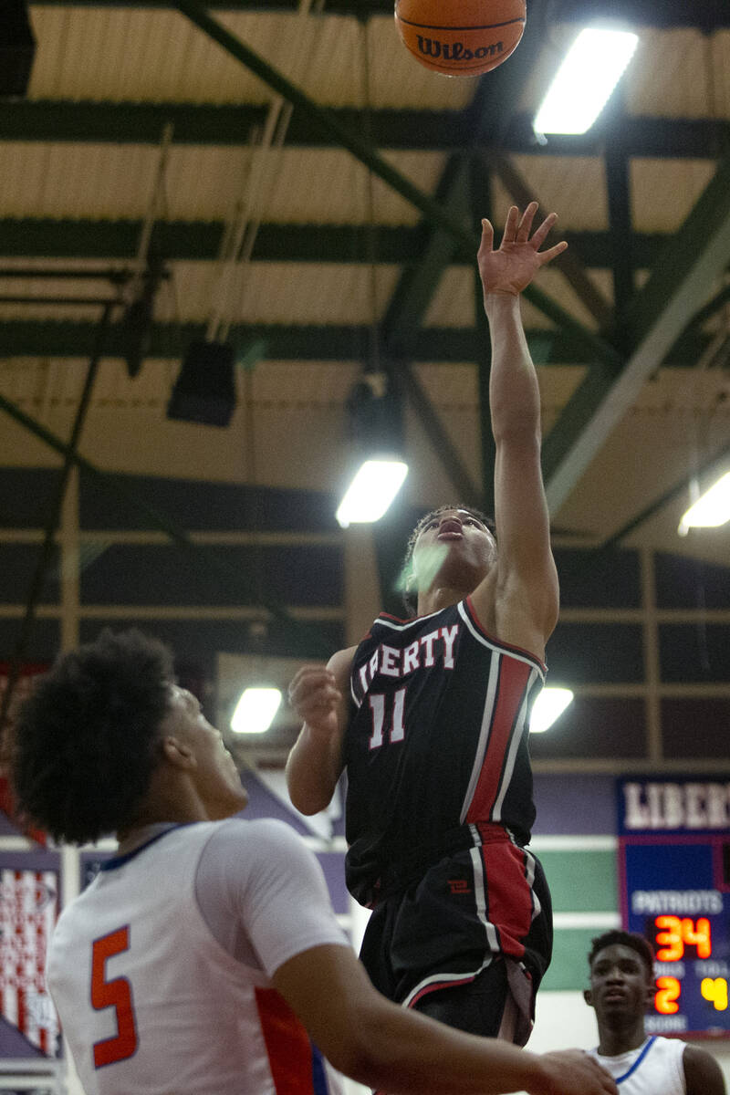 Liberty’s Dedan Thomas (11) shoots while Bishop Gorman’s Darrion Williams (5) and ...