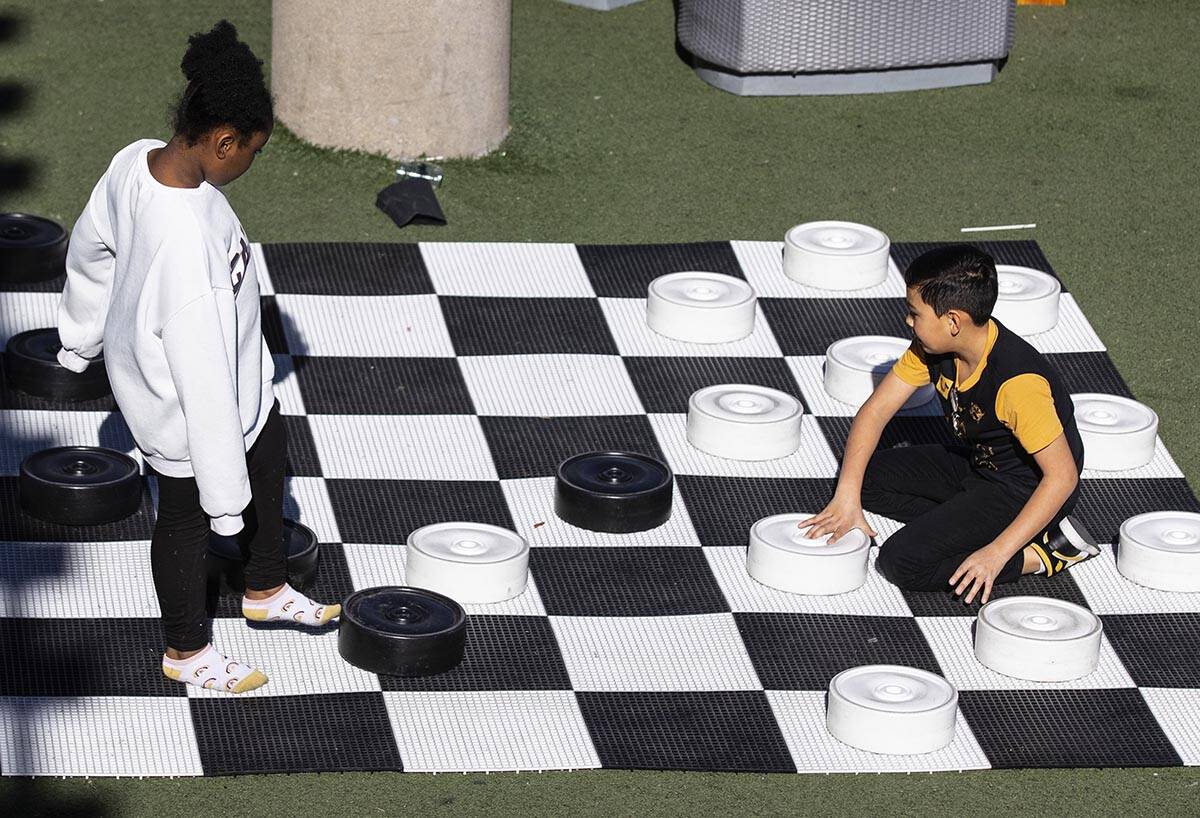 Kay Williams, 7, and Sebastian Gomez, 10, both of Las Vegas, play checkers at Container Park in ...