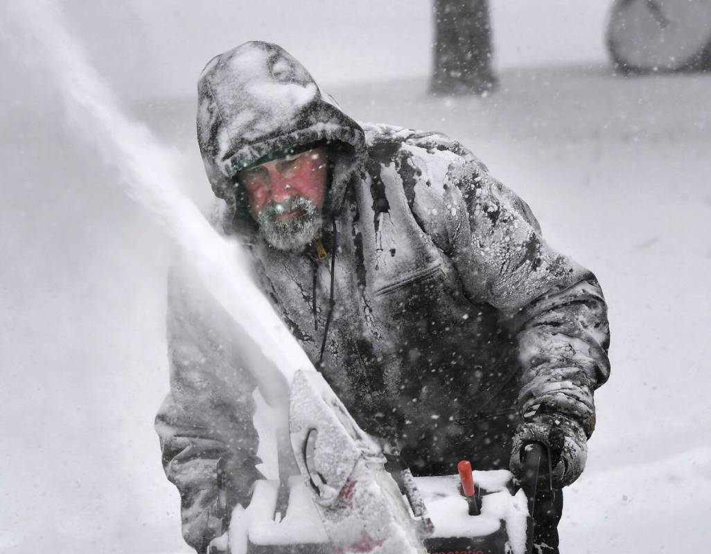 Dale McElwee clears his Green Street, North Attleboro, Mass. property of snow on Saturday, Jan. ...