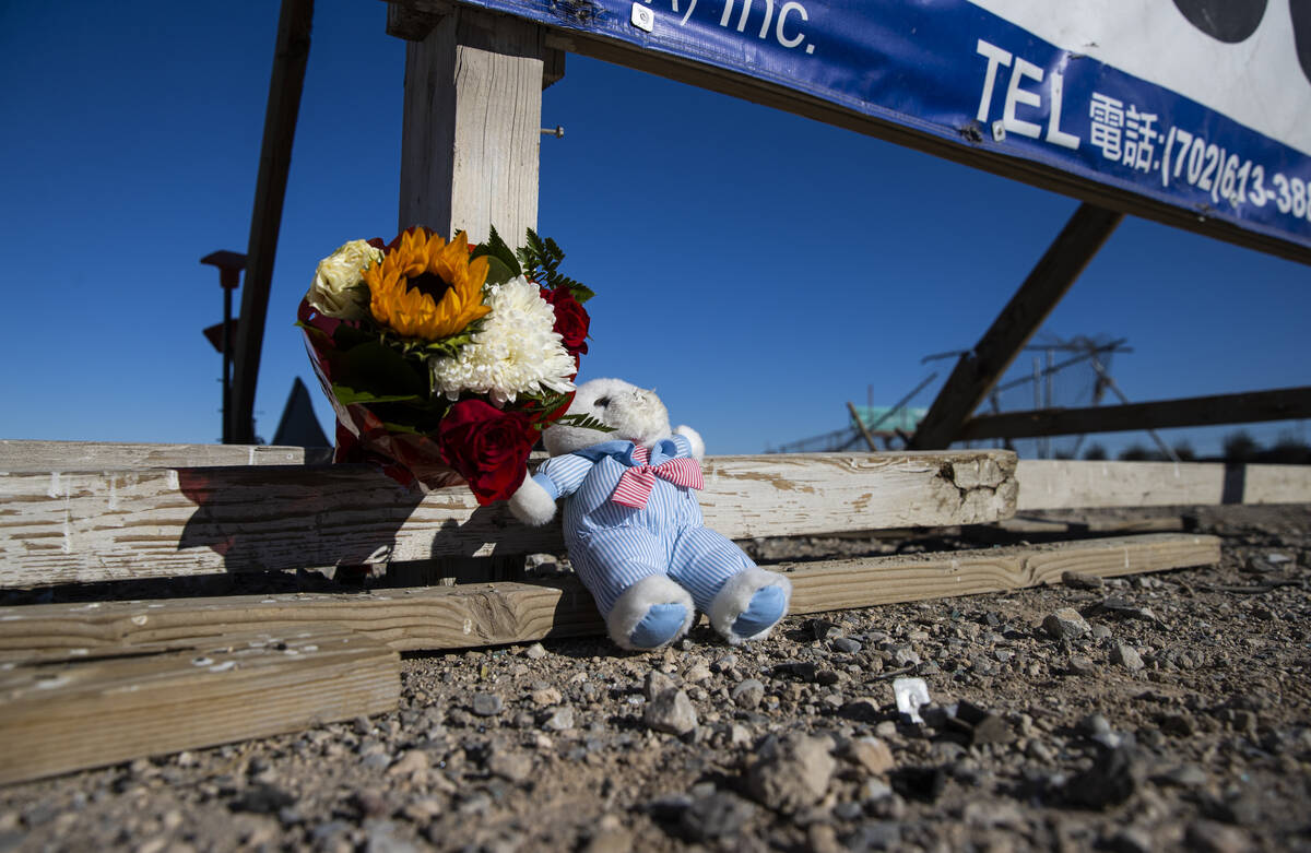 Flowers and a teddy bear are seen by the location of "a mass casualty traffic collision&qu ...