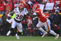 Cincinnati Bengals running back Joe Mixon fights off this tackle by Kansas City Chiefs middle l ...