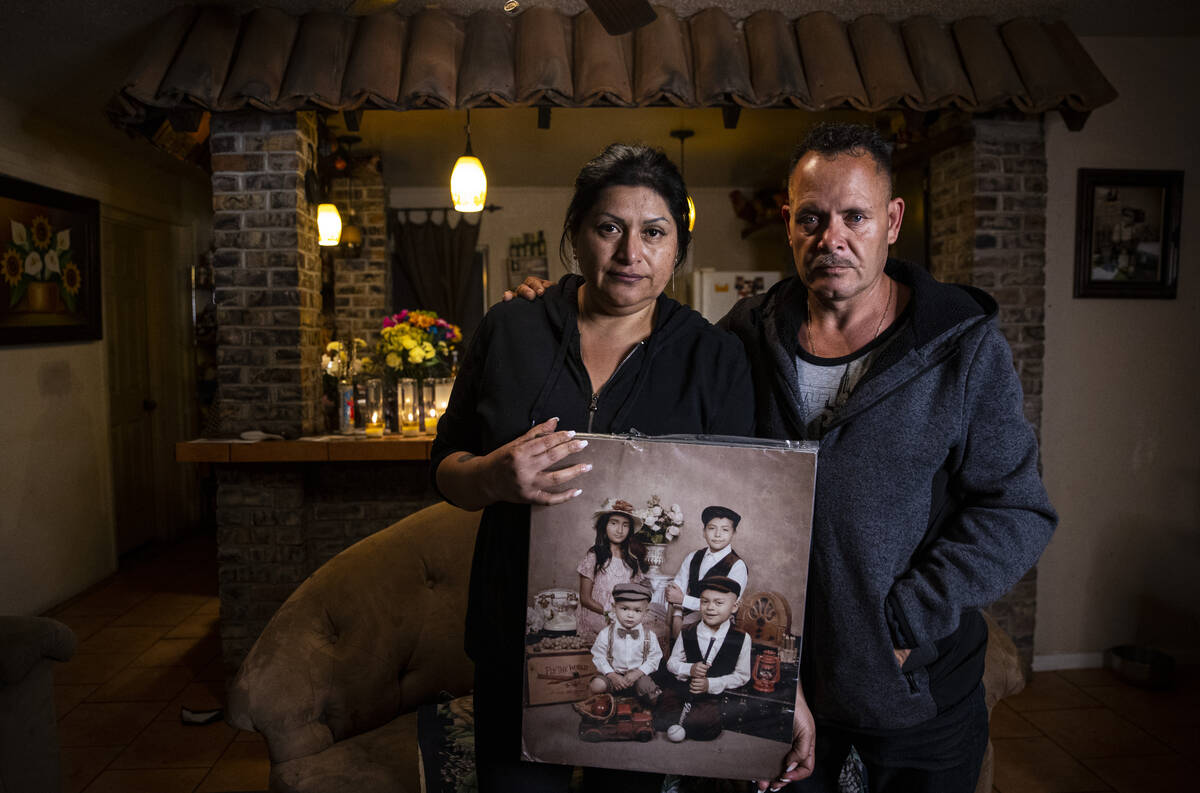 Erlinda Zacarias, left, and husband Jesus Mejia-Santana hold a portrait showing four of their s ...