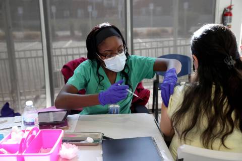 Adwoa Fosu gives a shot to Olivia Ramirez of Las Vegas at a COVID-19 vaccination station at Sou ...