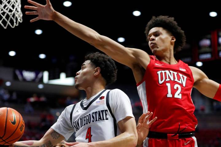 San Diego State's Trey Pulliam (4) shoots around UNLV's David Muoka (12) during an NCAA college ...