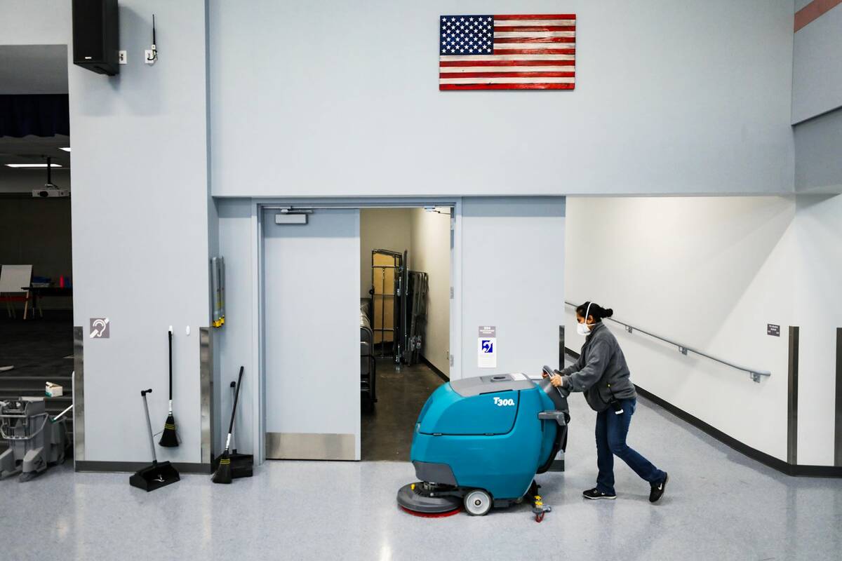 Head custodian Sonia Fernandez cleans the floor with a Tennant walk-behind floor scrubber at Fe ...