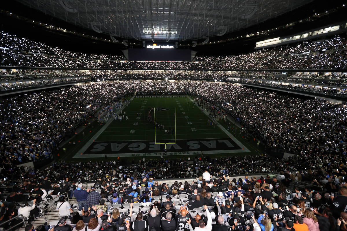 Fans light their phones during a moment of silence for legendary coach John Madden light the Al ...