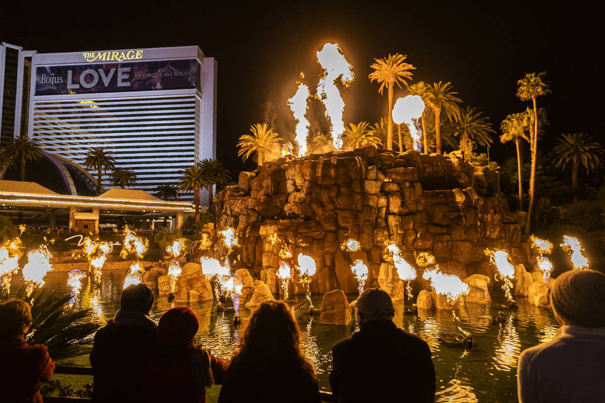 People watch the volcano show on the Strip outside the The Mirage on Wednesday, Jan. 26, 2022, ...