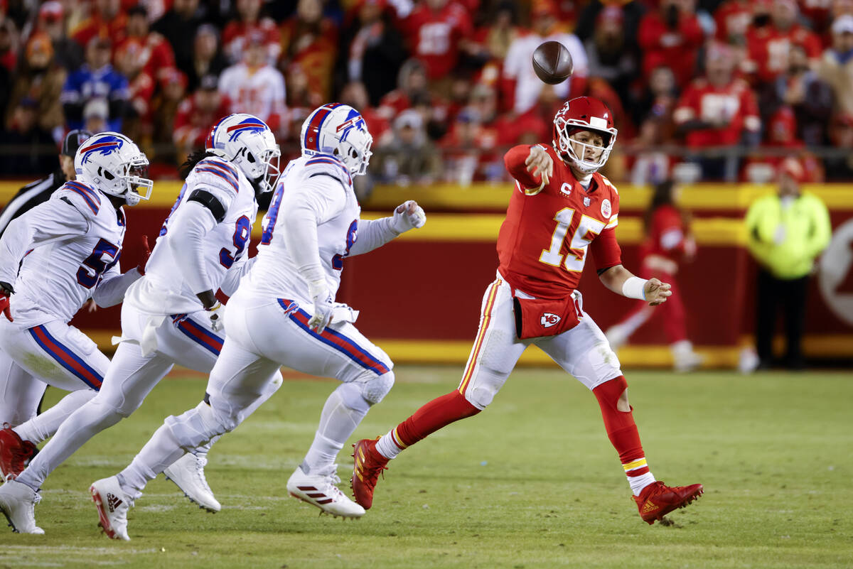 Kansas City Chiefs quarterback Patrick Mahomes (15) throws a pass on the run as he is chased by ...