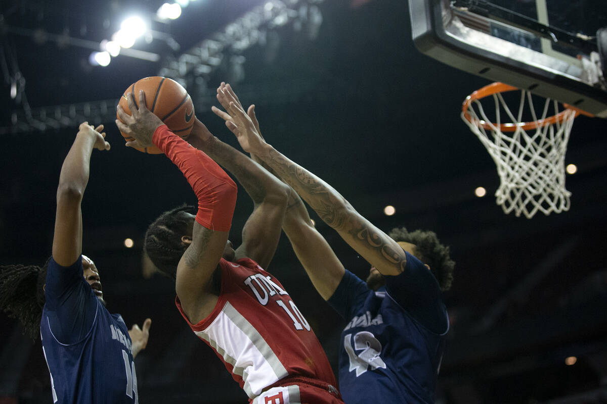 UNLV Rebels guard Keshon Gilbert (10) shoots against Nevada Wolf Pack forward Tre Coleman (14) ...