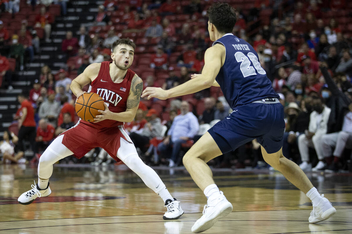 UNLV Rebels guard Jordan McCabe (5) looks to pass while Nevada Wolf Pack guard Daniel Foster (2 ...