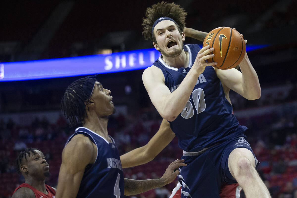 Nevada Wolf Pack center Will Baker (50) blocks a UNLV Rebels shot while Nevada Wolf Pack guard ...