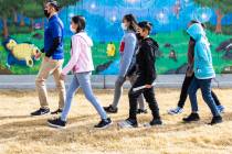 Augustin Luna, a Communities In Schools (CIS) site coordinator, left, walks with his English La ...