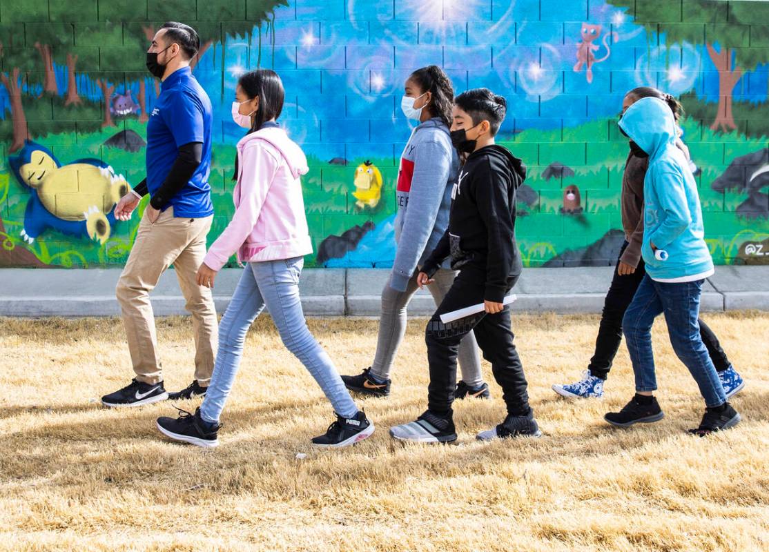 Augustin Luna, a Communities In Schools (CIS) site coordinator, left, walks with his English La ...