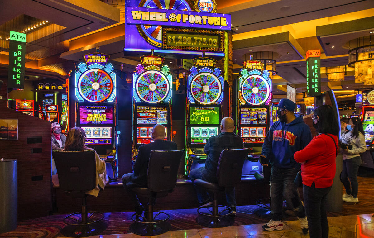 Guests play the Wheel of Fortune slots game as others watch at Red Rock Casino on Tuesday, Dec. ...