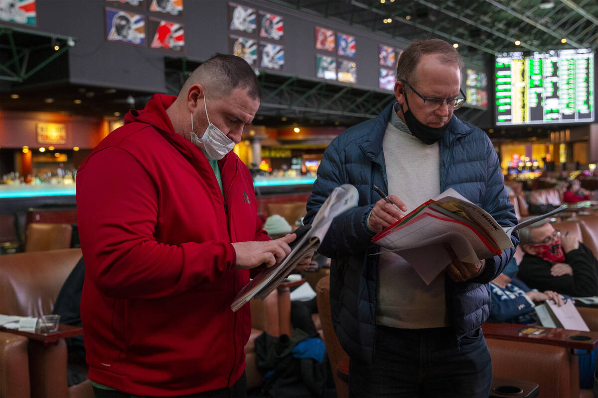 Jason Cee, of Florida, left, and Ken Fowler, of California, wait in line to place Super Bowl pr ...