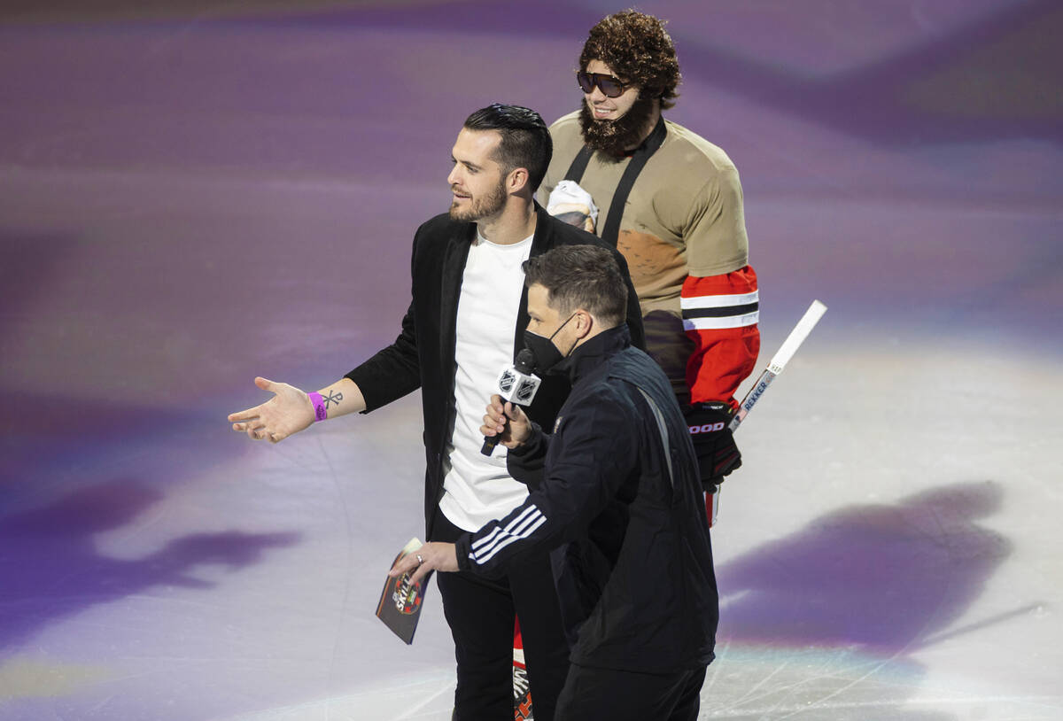 Chicago Blackhawks left wing Alex DeBrincat, top/right, Raiders quarterback Derek Carr and host ...