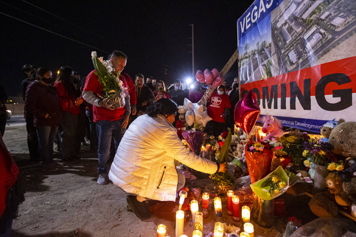 Erlinda Zacarias, right, and husband Jesus Mejia-Santana, left, place flowers at a memorial dur ...