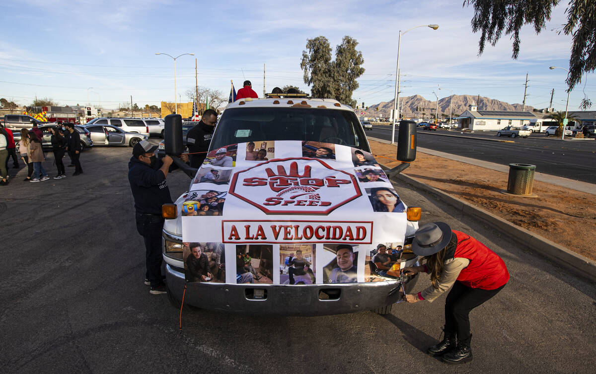 Martha Hernandez, right, of North Las Vegas, helps set up a banner before a vehicle caravan in ...