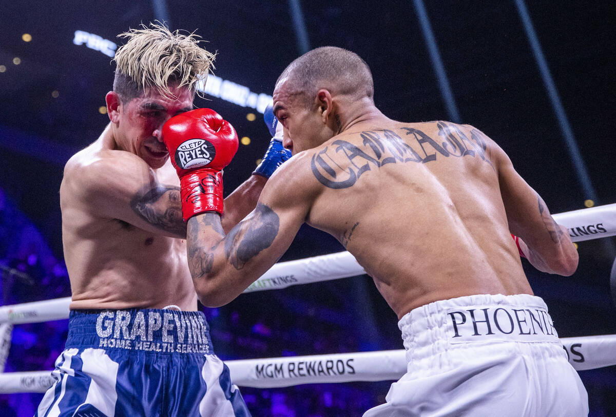 Leo Santa Cruz, left, takes a pinch in the face from and Keenan Carbajal during the second roun ...