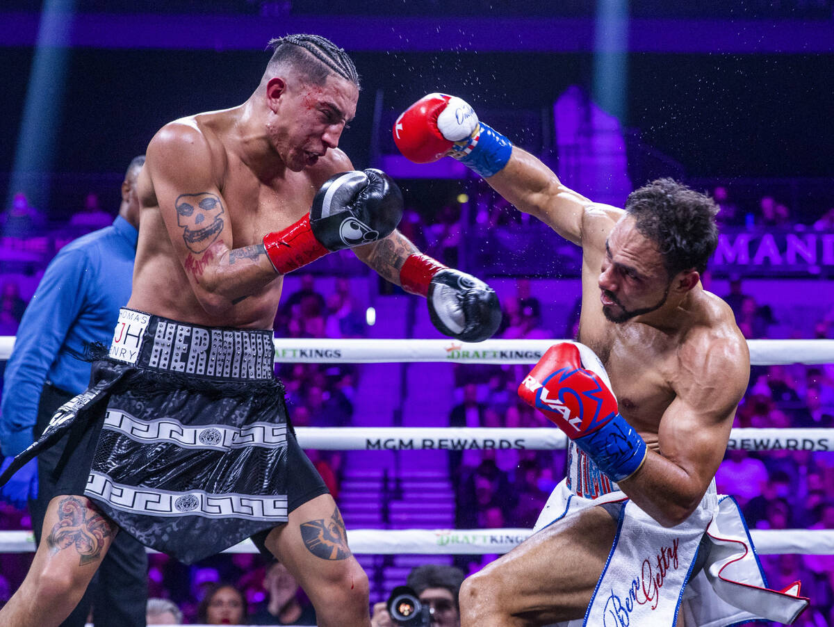Mario Barrios, left, takes a punch from Keith Thurman during the fourth round of their Welterwe ...