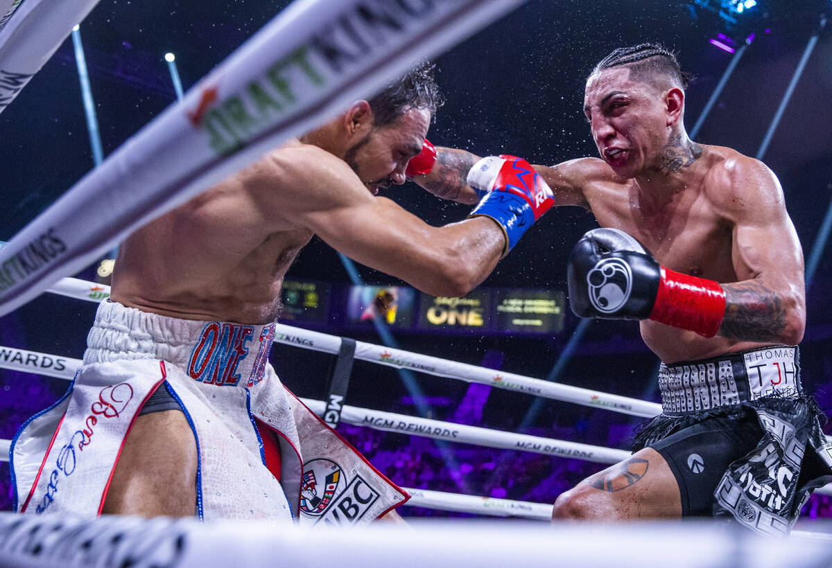 Keith Thurman, left, takes a punch to the head from Mario Barrios during the tenth round of the ...