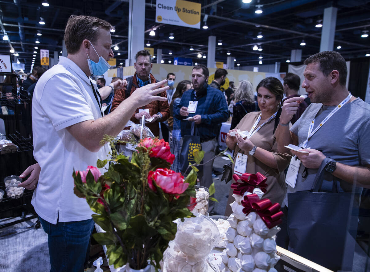 Oliver Dardain of La Provence Inc., left, talks to potential buyers as they test Birthday cakes ...