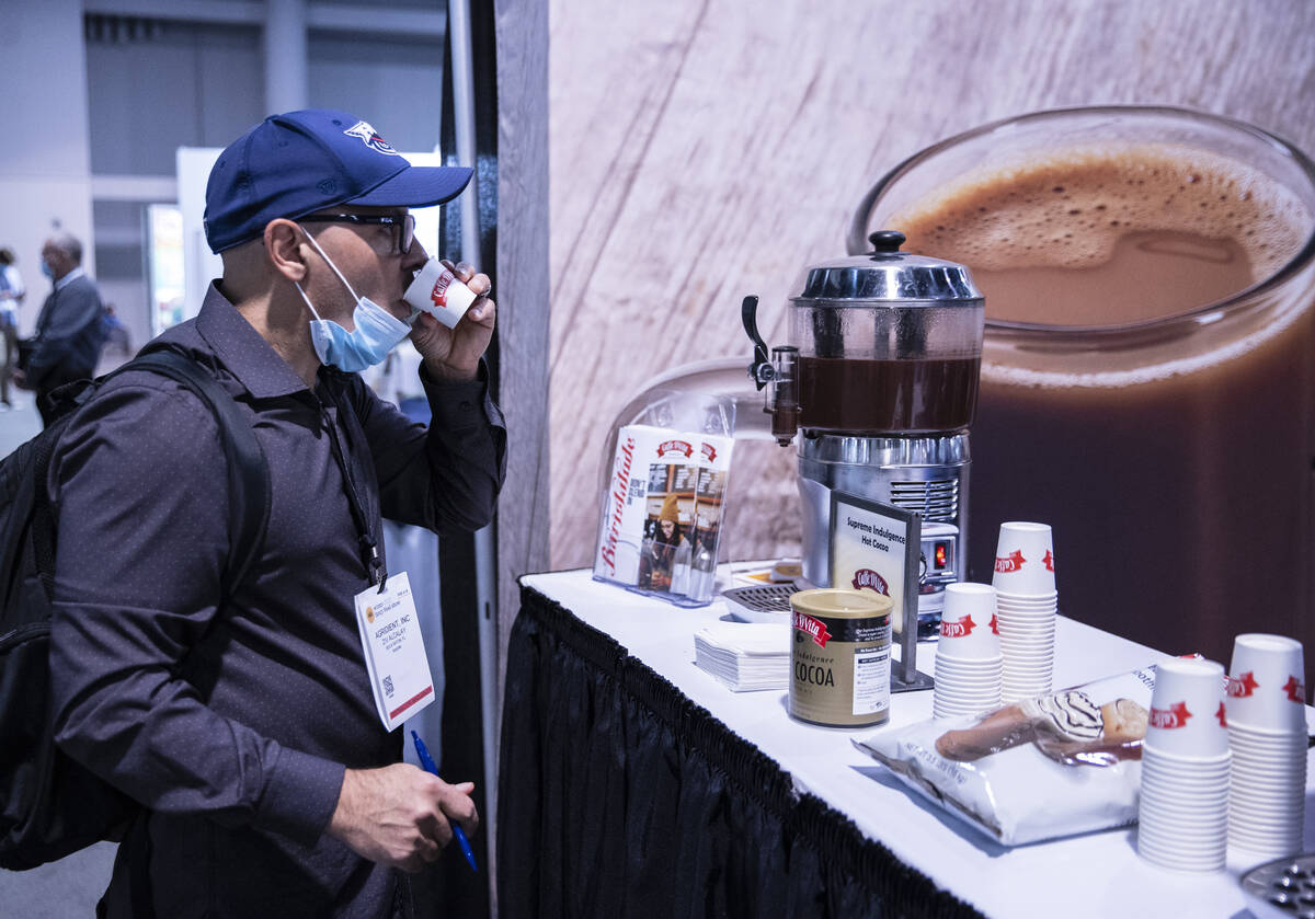 Ziv Allay of Boca Raton, Fla., tests hot cocoa at Cafe D’Vita booth during the Fancy Food Sh ...