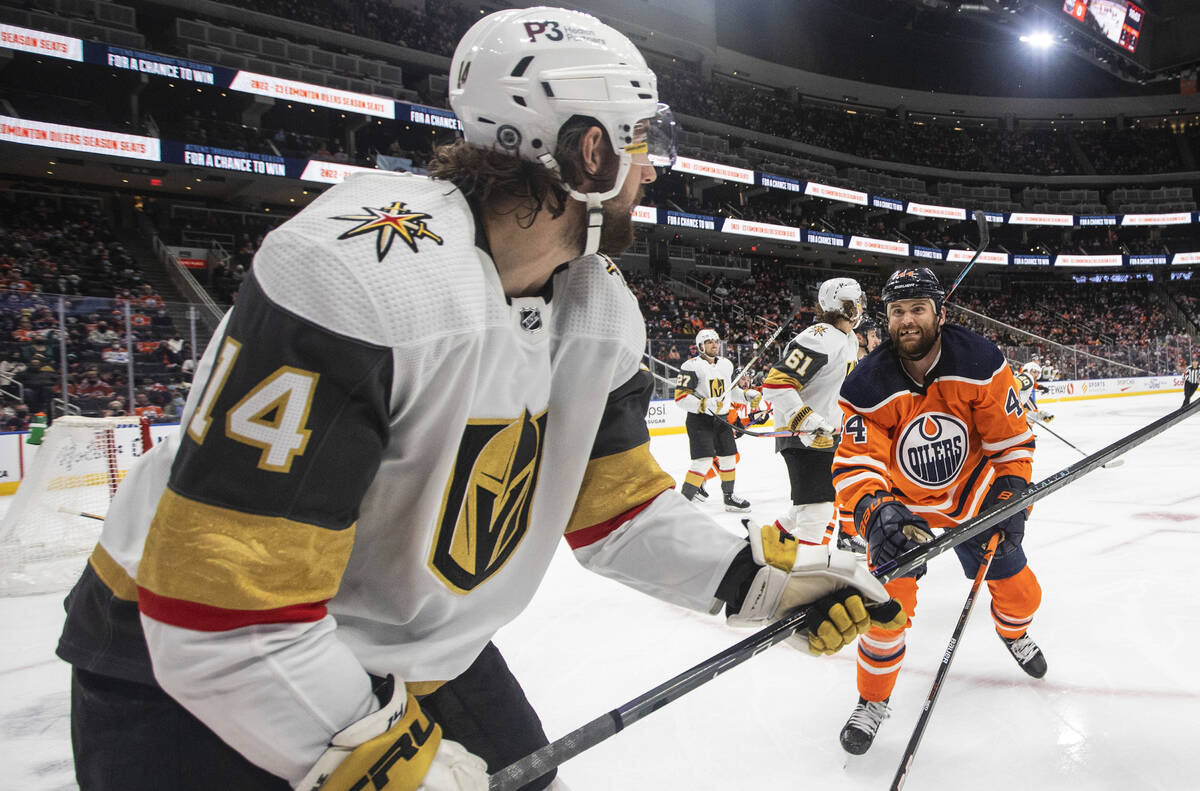 Vegas Golden Knights' Nicolas Hague (14) gets rid of the puck as Edmonton Oilers' Zack Kassian ...