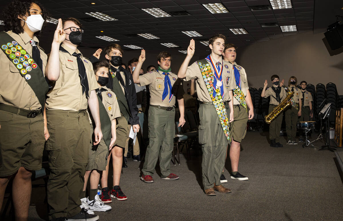 Cash Karlen, of Boy Scout Troop 912, center right, participates in the Scout Oath before being ...