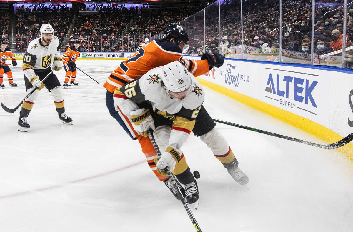 Vegas Golden Knights' Mattias Janmark (26) checks Edmonton Oilers Tyson Barrie (22) during the ...