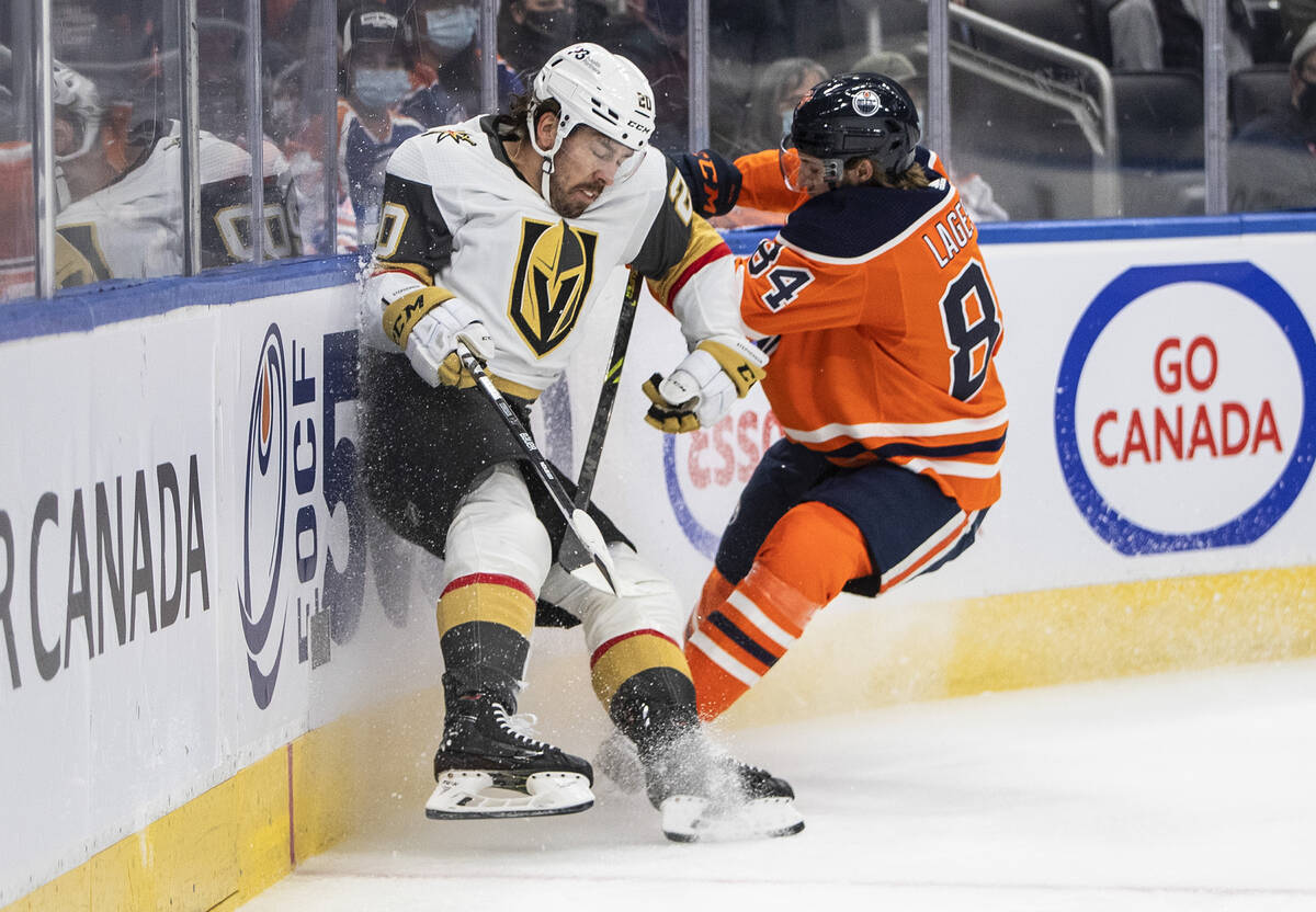 Vegas Golden Knights' Chandler Stephenson (20) is checked by Edmonton Oilers William Lagesson ( ...