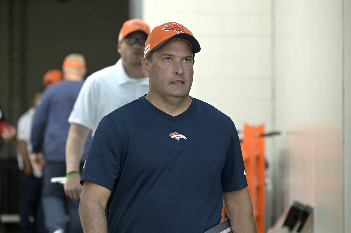 Denver Broncos special teams coordinator Tom McMahon walks to the field before an NFL football ...