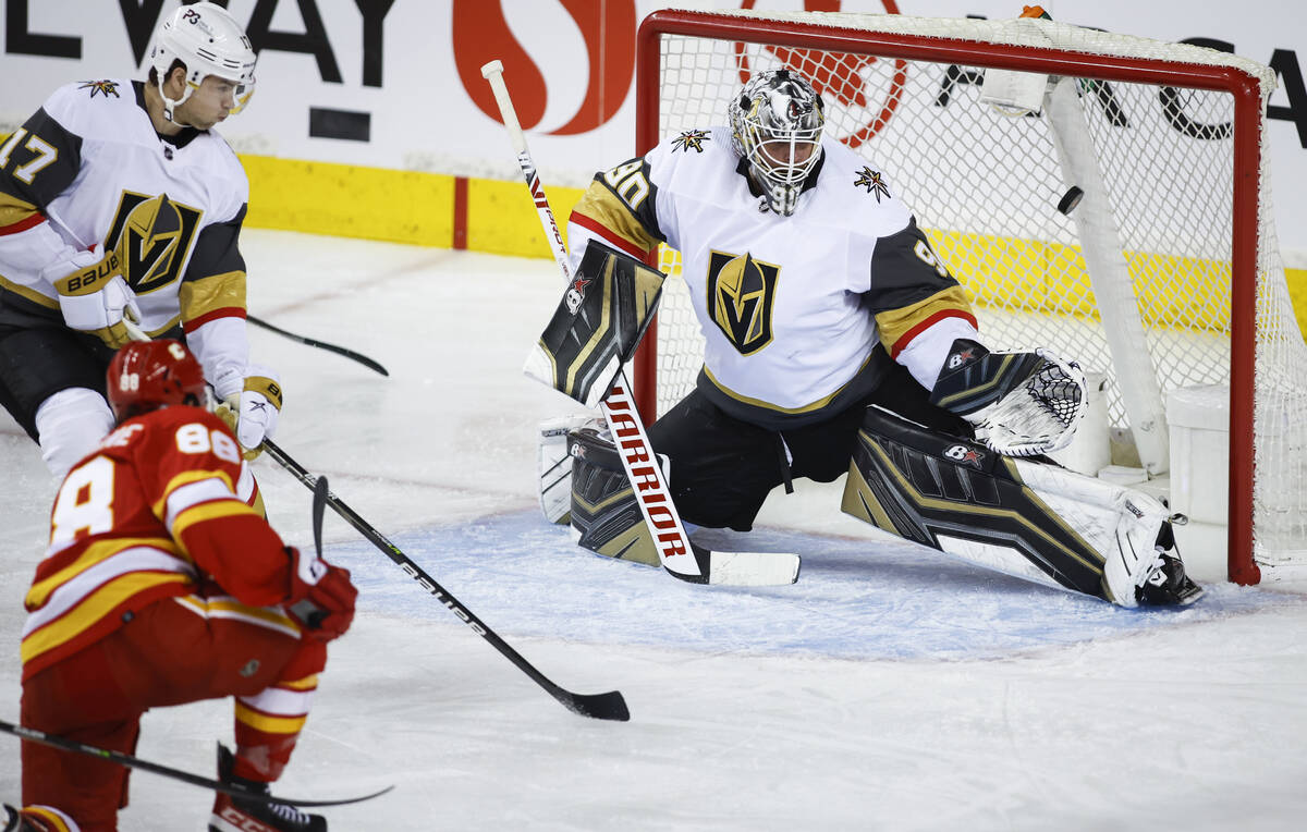 Vegas Golden Knights goalie Robin Lehner, right, lets in a goal from Calgary Flames' Andrew Man ...
