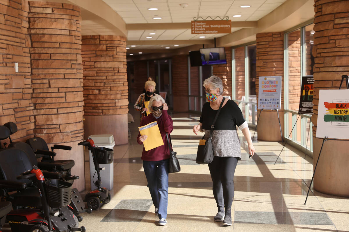 People wear masks at the Clark County Government Center following Gov. Steve Sisolak’s a ...