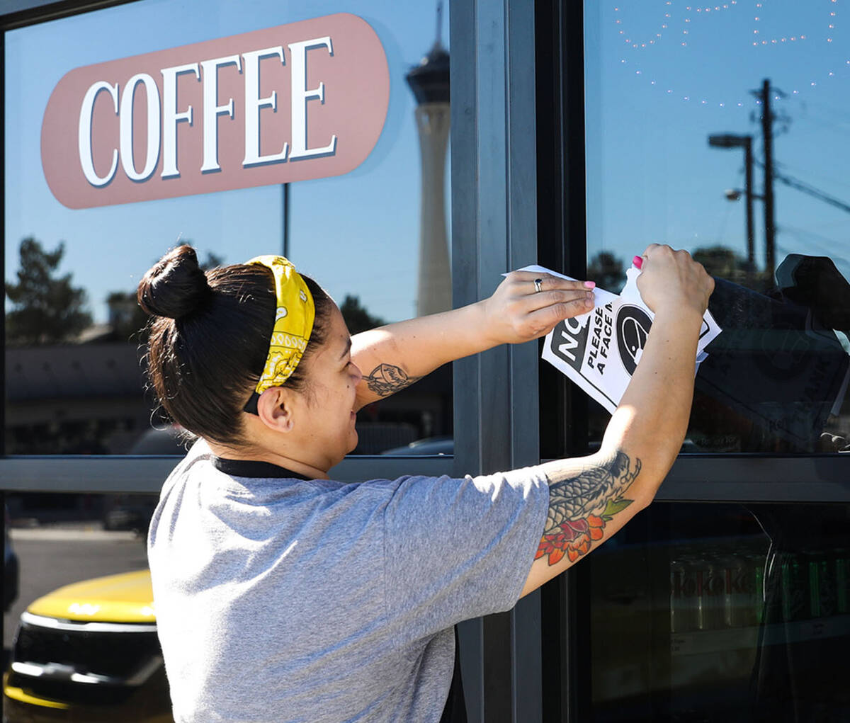 Saige Molina, manager at Real Donuts, tears up a mask mandate sign on Thursday, Feb. 10, 2022. ...