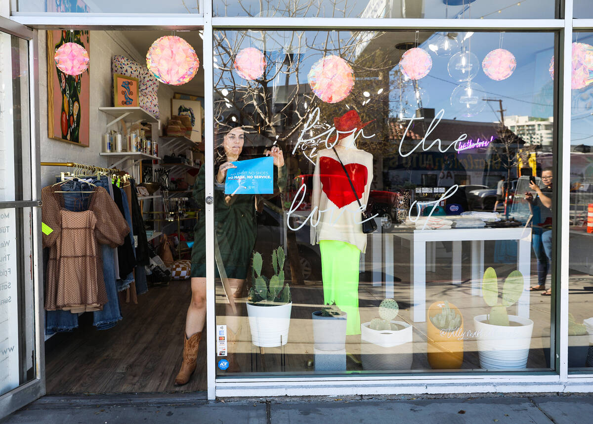 Emily Johnson, owner of For the love, LV, a boutique store in the Arts District, takes down a m ...