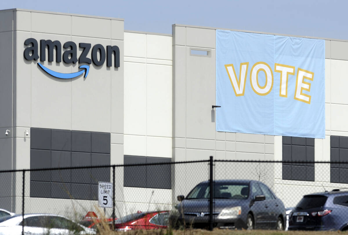 FILE - A banner encouraging workers to vote in labor balloting is shown at an Amazon warehouse ...